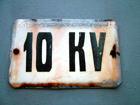 Grunge warnings table, limit 10 kilo voltage, a wall and edge of table are paintedの写真素材