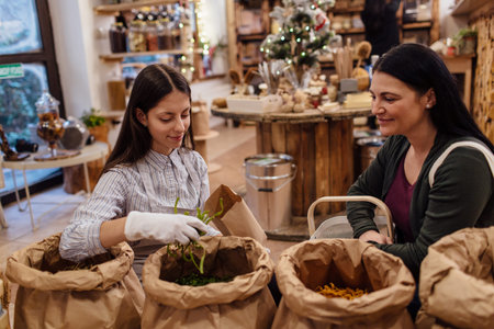 Shop assistant serving customer in packaging free shop. Zero waste shopping - woman buying fresh...