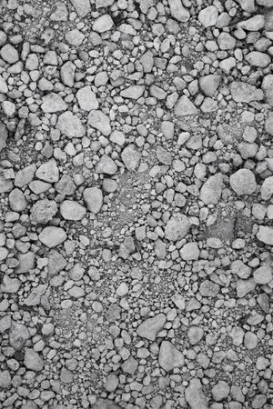 Grayscale closeup of rough rocky soil. Useful as industrial and agricultural wallpaper or template of background for website, blog, article or advertisement. Can be used as backdrop for objects photosの写真素材