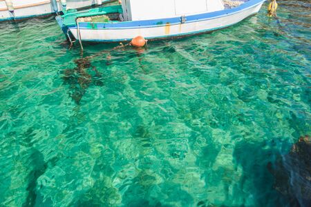 Boat in a clear turquoise sea water on island Kalymnosの写真素材