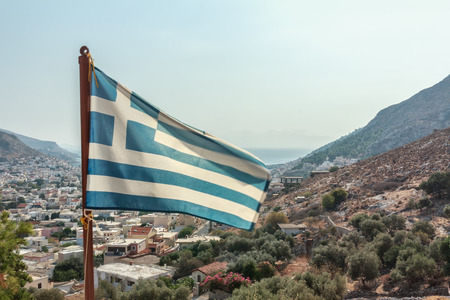 Flag of Greece is waving at Pothia cityscape the capital of Kalymnos island backgroundの写真素材