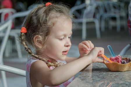 Little girl is eating her Italian ice cream wafer coneの写真素材