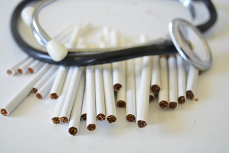 Stethoscope and cigarettes on white background, medicine, healtsの写真素材