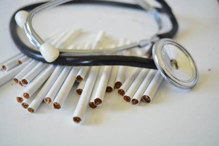 Stethoscope and cigarettes on white background, medicine, healtsの写真素材