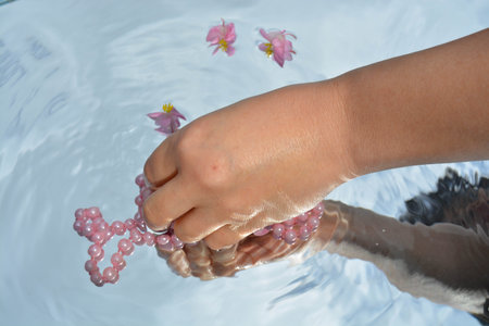 Pearls and hands reflected in pure water