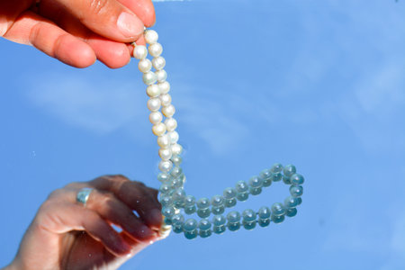 Pearls and hands reflected in pure water