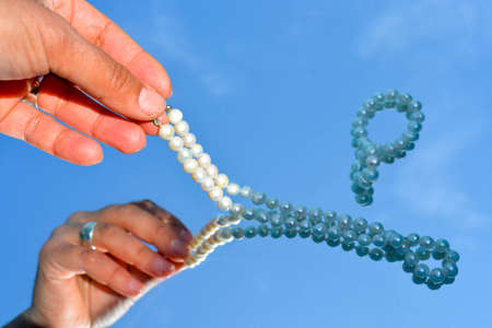 Pearls and hands reflected in pure waterの写真素材