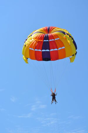 Parachute and parachutist on blue sky backgroundの写真素材