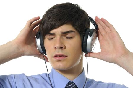 Young man listening music isolated on whiteの写真素材