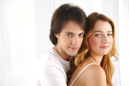 Attractive young couple in love, smiling and embracing each otherの写真素材