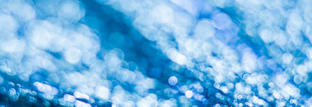 Blue abstract background with bokeh defocused lightsの写真素材