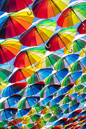 Colorful umbrellas Blue, green, red, rainbow umbrellas background Street with umbrellasin the skyの写真素材