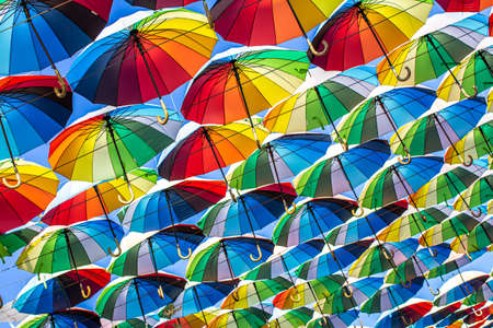 Colorful umbrellas Blue, green, red, rainbow umbrellas background Street with umbrellasin the skyの写真素材