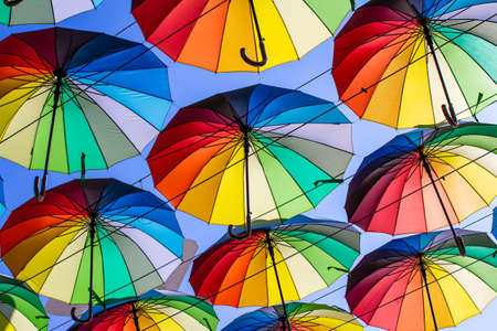Colorful umbrellas Blue, green, red, rainbow umbrellas background Street with umbrellasin the skyの写真素材