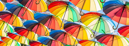Colorful umbrellas Blue, green, red, rainbow umbrellas background Street with umbrellasin the skyの写真素材
