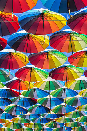 Colorful umbrellas Blue, green, red, rainbow umbrellas background Street with umbrellasin the skyの写真素材