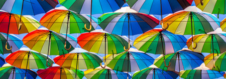 Colorful umbrellas Blue, green, red, rainbow umbrellas background Street with umbrellasin the skyの写真素材
