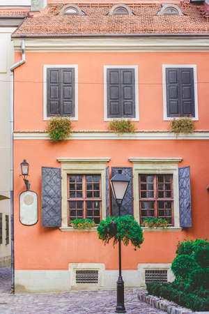 Old windows on the background of an orange wall in the old courtyard of the city.の写真素材