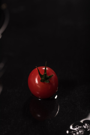 Tomatoes on black background ,water drops ,closeup ,  mirrorの写真素材