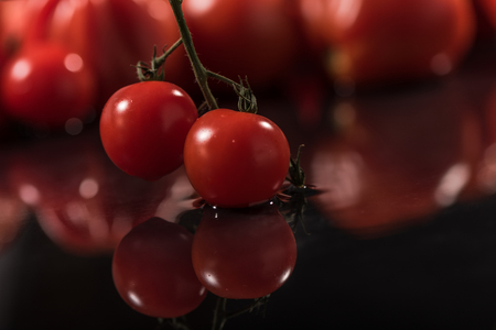 Tomatoes on black background ,water drops ,closeup ,  mirrorの写真素材