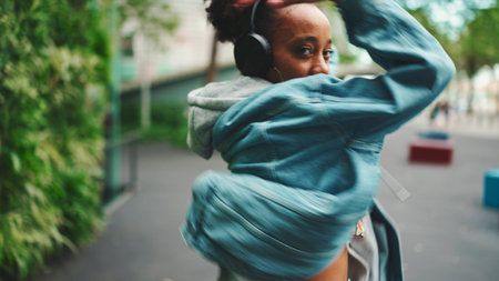 Closeup, smiling African girl wearing denim jacket, in crop top with national pattern walks in city...