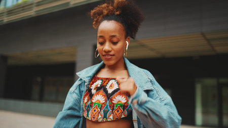 Closeup, smiling African girl with ponytail wearing denim jacket, in crop top with national pattern...