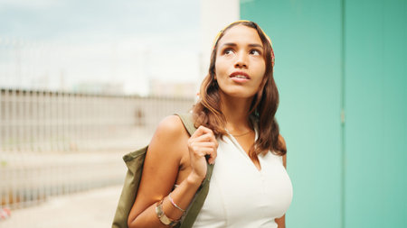 Beautiful girl with tanned skin, brown long hair wearing wireless headphones. Cute young woman with...
