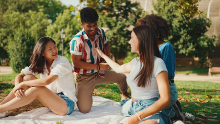 Happy smiling young multinational people at picnic on summer day outdoors. Friends have fun weekend...