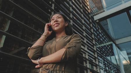 Young businesswoman talking on smartphone on business center backgroundの写真素材
