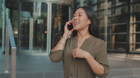 Young businesswoman talking on smartphone on business center backgroundの写真素材