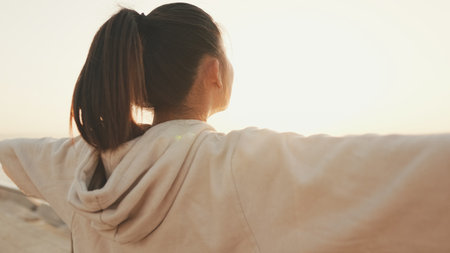Asian girl in sportswear doing workout, breathing exercises, relaxing on modern buildings background at morning timeの写真素材