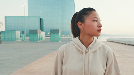 Asian girl wears sportswear walking outside at morning timeの写真素材