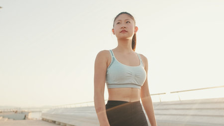 Asian girl in sports top walking outside at morning timeの写真素材