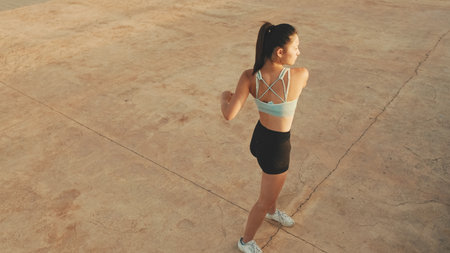 Asian girl in sports top does workout, stretching and gymnastics at morning time. View from aboveの写真素材