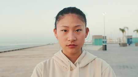 Close up of asian girl wearing sportswear looking at camera at morning timeの写真素材