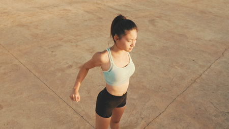 Asian girl in sports top does workout, stretching and gymnastics at morning time. View from aboveの写真素材