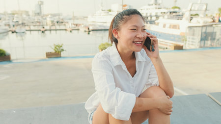 Young woman talking on mobile phone on seascape backgroundの写真素材