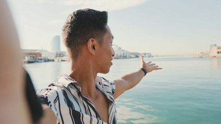 Close-up of young man standing on dock taking selfie with cell phone