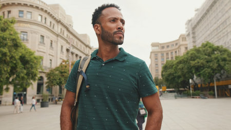 Young man tourist walks along the square of the old city, considers the sights