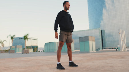 Young bearded male athlete doing workout, squats and jumping on the waterfront
