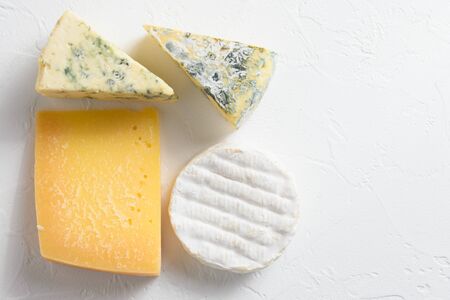 Cheese platter: yellow Maasdam, white Camembert and blue cheese Dor Blue on white background. Copy space. Concept serving cheese. Top view.の写真素材