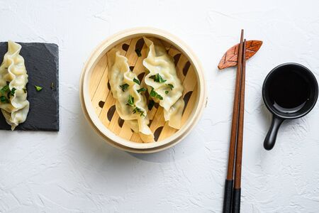 Close up fresh boiled gyoza dumplings in wooden bamboo steamer with soy sauce top view.の写真素材