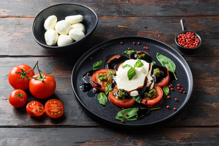 Italian food - caprese salad with sliced tomatoes, mozzarella cheese, basil, olive oil. Served on...