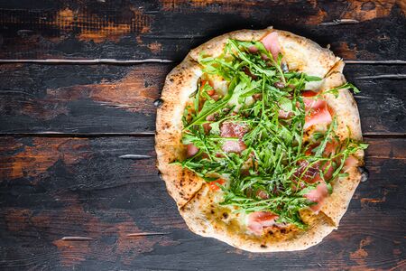 Homemade pizza with mozzarella, cheese and basil leaves onwooden planks. Top view space for text.の写真素材
