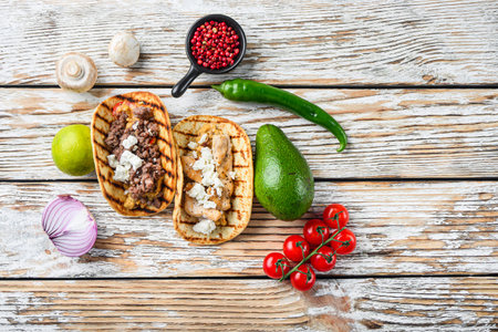 Homemade taco with chicken and beef near raw ingredients over white textured old table, top view...