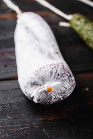 Spanish longaniza sausages on dark wood background.