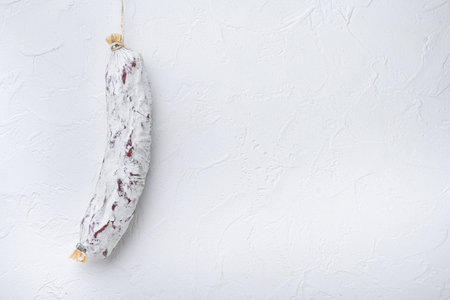 Salami sausage salchichon on white background with space for text.