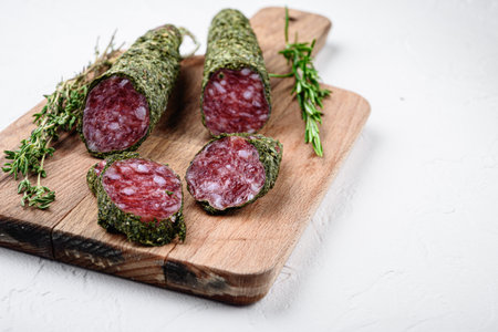 Sliced cuts of fuet salami sausage on white textured background with space for text.の写真素材