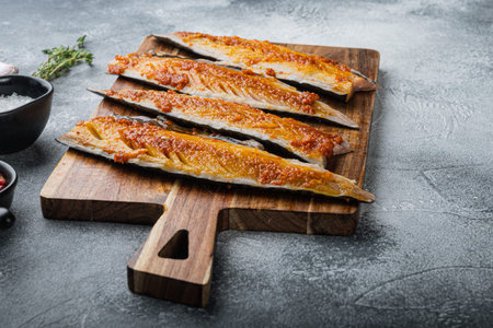 Marinated scomber fillet with paprika and saffron on gray background.