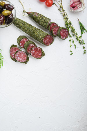 Traditianal fuet sausage in herbs with ingredients on white textured background, topview with space for text.の写真素材